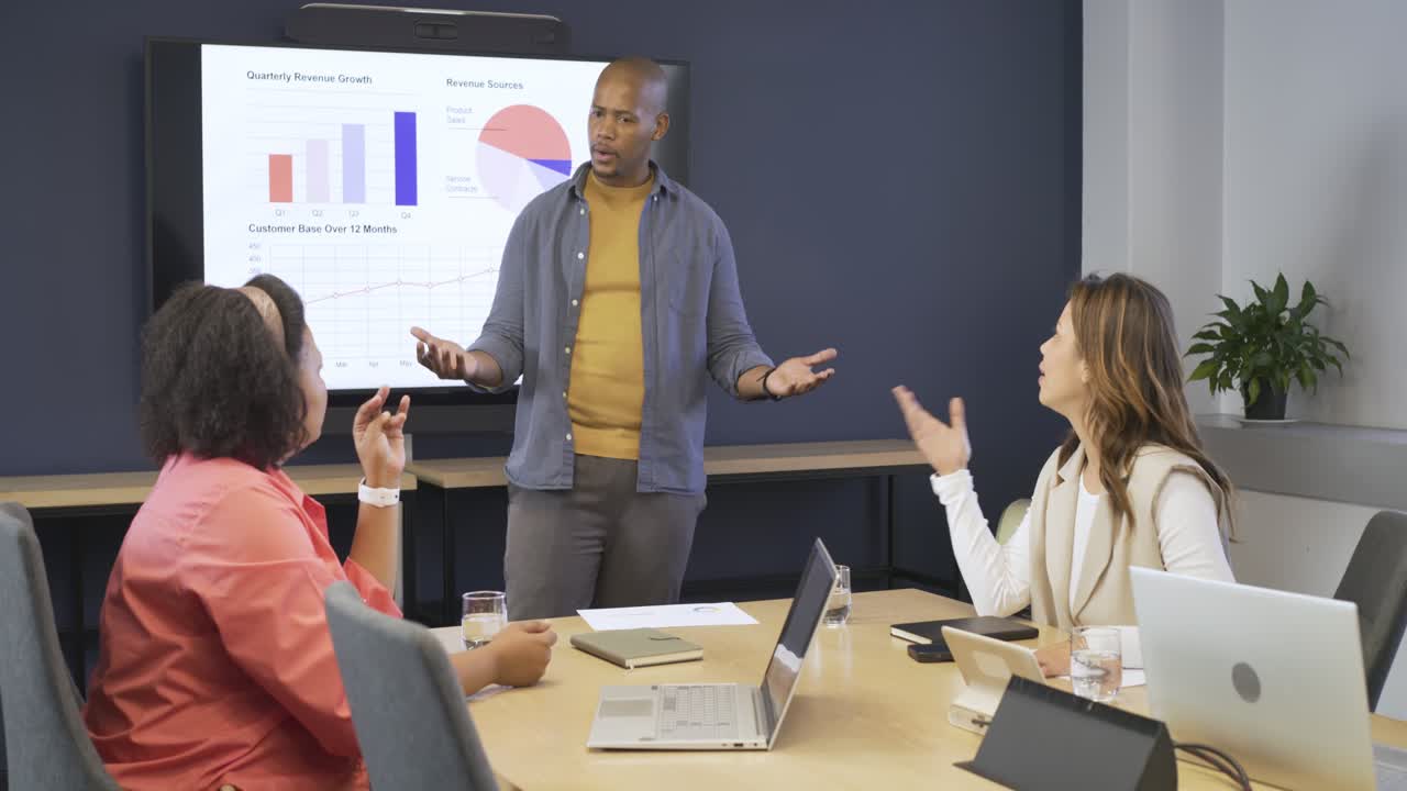Presenter offering report pointing at charts in office, Diverse team seeking feedback, copy space