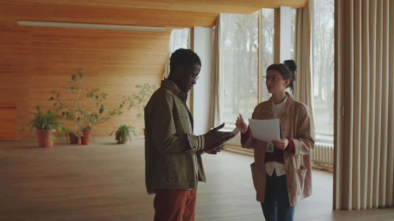 Multiethnic Colleagues Discussing Documents in Library Auditorium