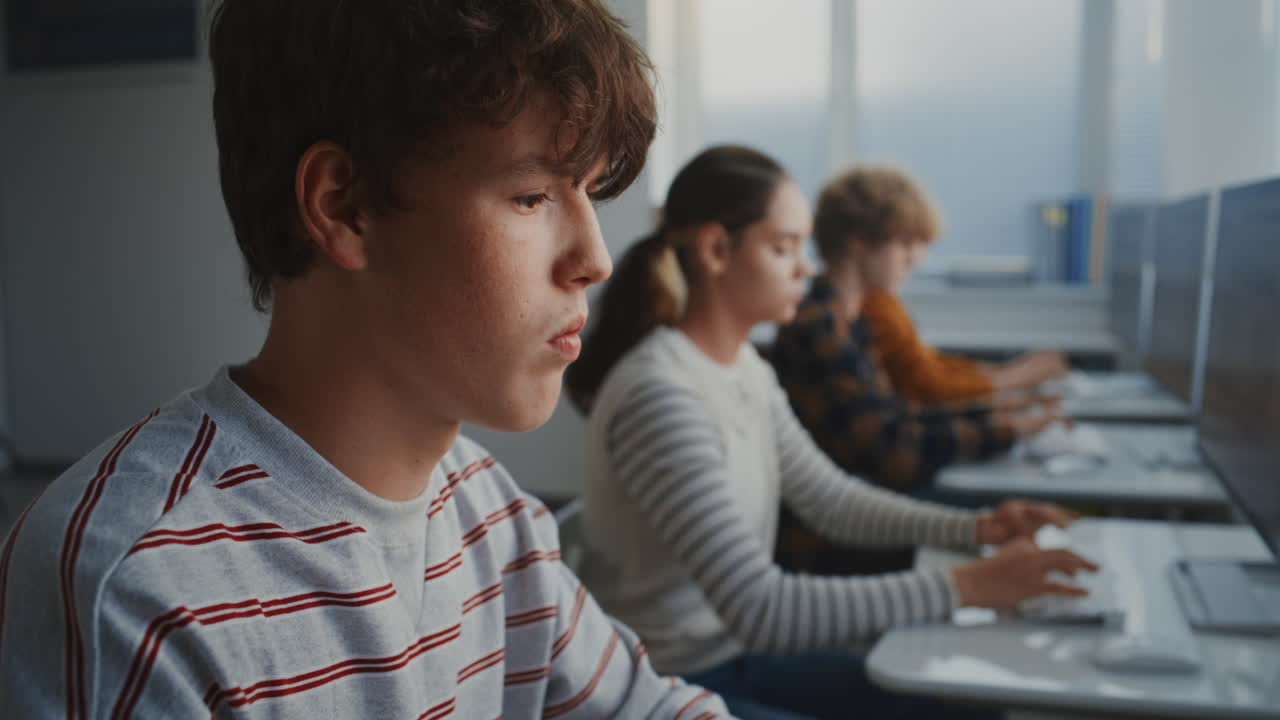 Serious Student Working With Code on Monitor During Class
