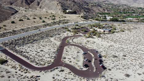 car parking lot on highway side in california desert, aerial drone shot