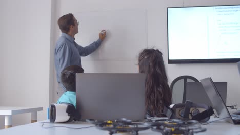 school teacher writing on whiteboard