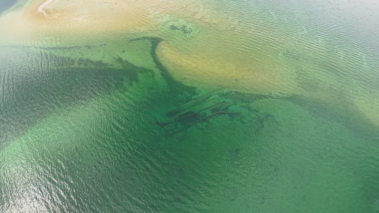 Aerial drone video of shipwreck underwater along sandbar