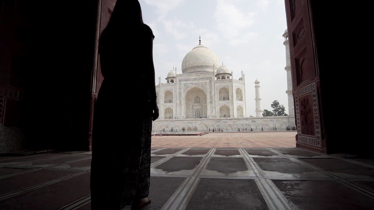 mujer vestida caminando hacia el taj mahal