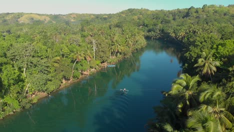 Enthüllen-Sie-Eine-Luftdrohne,-Die-Während-Des-Sonnenuntergangs-Von-Einem-Lokalen-Philippinischen-Boot-Auf-Dem-Loboc-Fluss,-Umgeben-Von-Palmen-Und-Grünen-Wäldern,-Auf-Der-Insel-Bohol-Auf-Den-Philippinen-Aufgenommen-Wurde