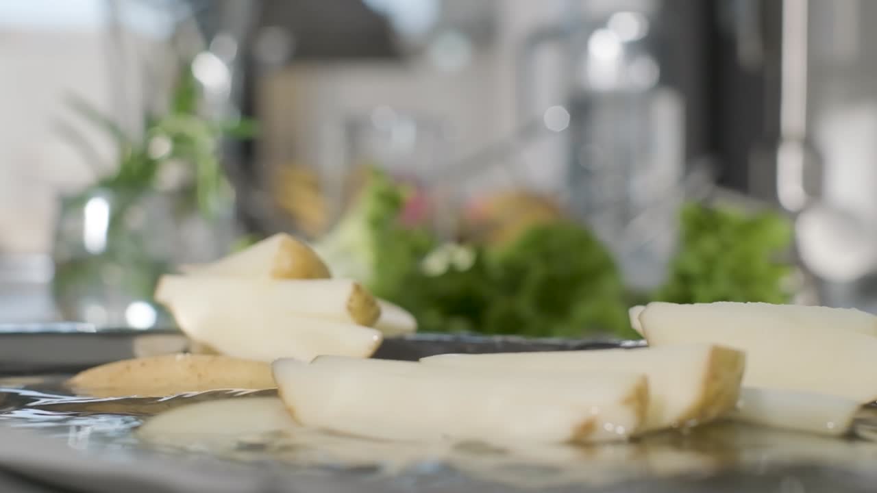Uncook And Unpeeled Potato Wedges Falls Into Plate With Water