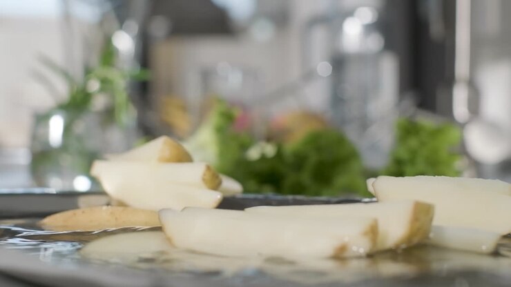 Uncook And Unpeeled Potato Wedges Falls Into Plate With Water