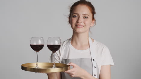 Redheaded-waitress-in-front-of-camera-on-gray-background.