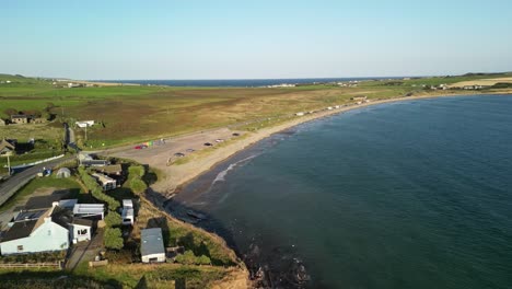 coastal road with houses and sandy beach from above