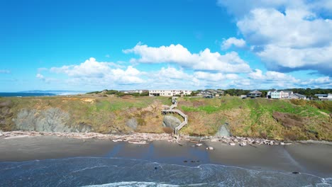 Gorgeous-4K-aerial-drone-shot-rising-above-ocean-water-facing-blue-sky-and-clouds