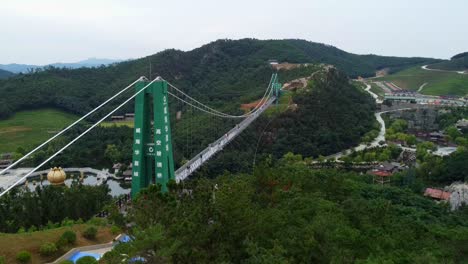 aerial view of suspension glass bridge at huaxiacheng theme park in weihai, china