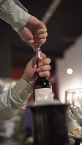 waiter uncorking a bottle of wine