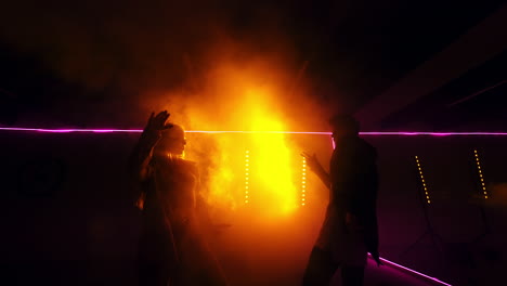 dark room with the bright yellow light projector. male and female dancers moving gracefully. low angle view.