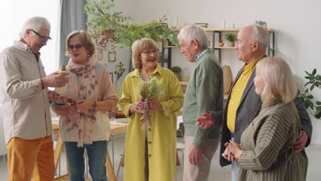 company of senior friends smiling and chatting at home