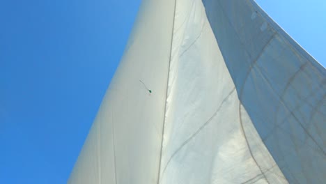 Vela-Blanca-Moviéndose-En-Una-Suave-Brisa-En-Un-Día-Soleado-De-Verano-Con-Un-Cielo-Azul-Claro