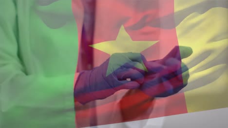 Animation-of-flag-of-cameroon-over-doctor-wearing-medical-gloves