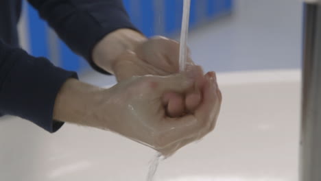 person washing - scrubbing their hands with care in clean laboratory environment