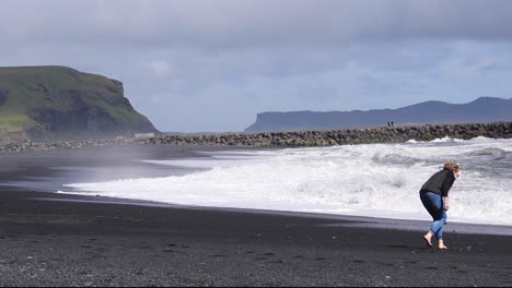 Frau-Am-Schwarzen-Strand-Von-Island-Zu-Fuß