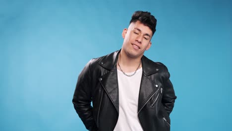 confident man looking at camera and smiling while folding his arms against an isolated background.