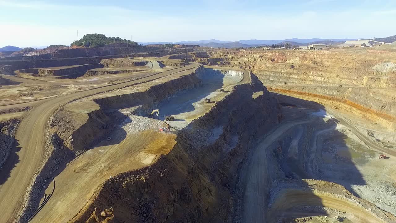 Heavy machinery working in te riotinto open pit copper mine aerial shot