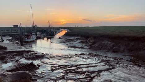 barcos atracados en el estuario con una increíble puesta de sol dorada