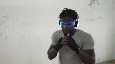 Boxer-practicing-shadowboxing-in-light-sport-studio-wearing-stylish-glasses