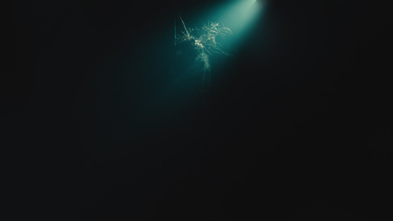 A creepy witch stands in the moody pose during the night storm