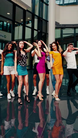 grupo de jóvenes bailando en un moderno centro comercial