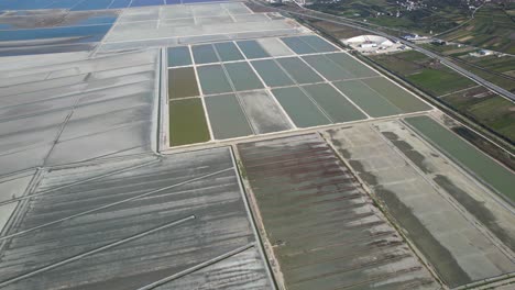 Large-salt-pools-with-salted-seawater-evaporating-on-coastline-of-Adriatic-sea-in-Vlora,-Albania