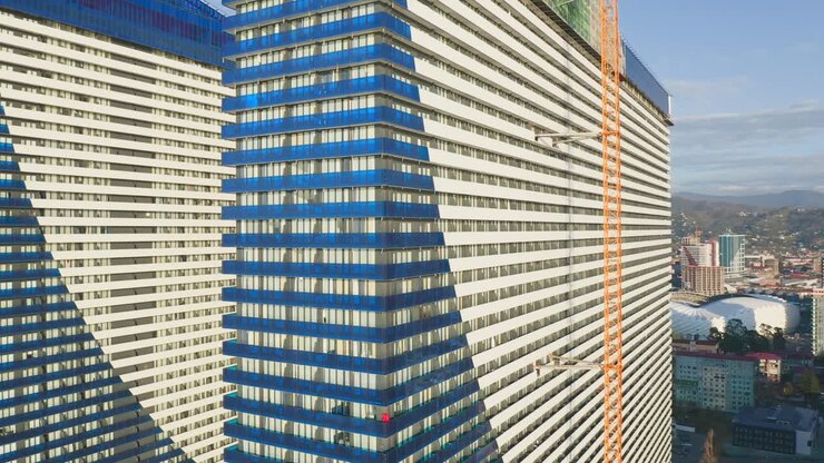 Metraje de dron alrededor de la fachada de un moderno rascacielos residencial en construcción