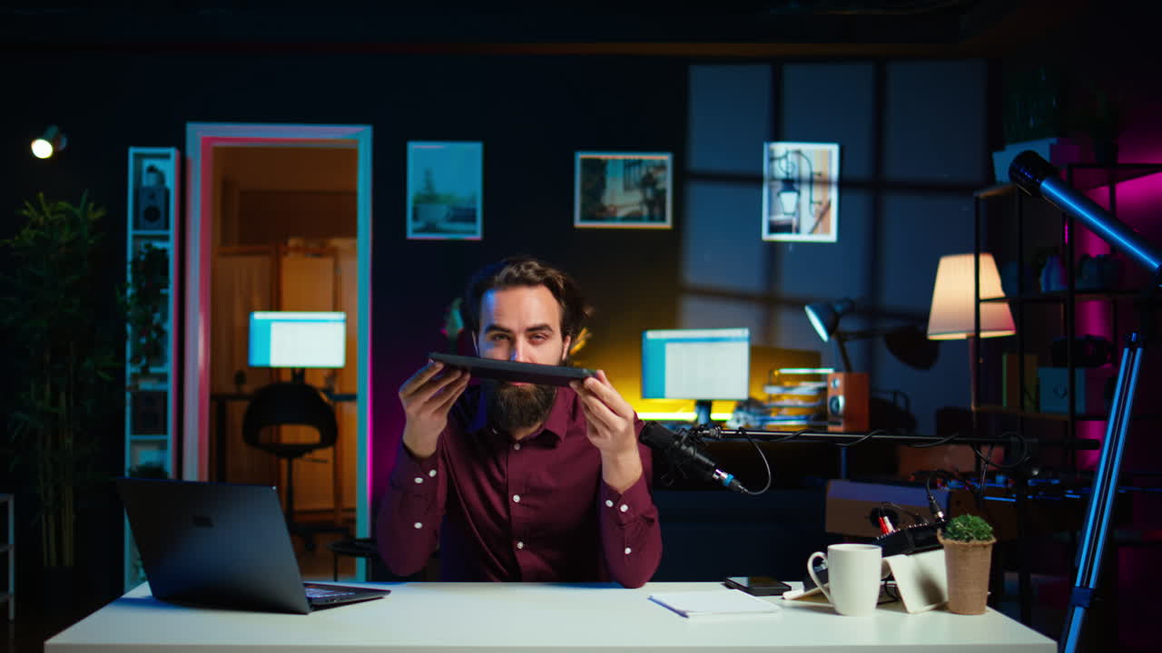 Man in studio films tablet video review per gli appassionati di tecnologia