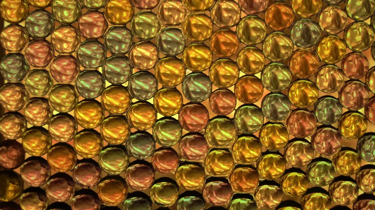 Mini globi di cristallo colorati che riflettono motivi di luce colorati; in loop.