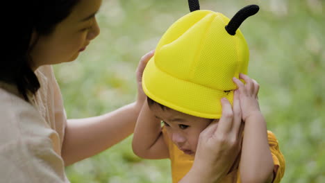 woman putting hat on her child