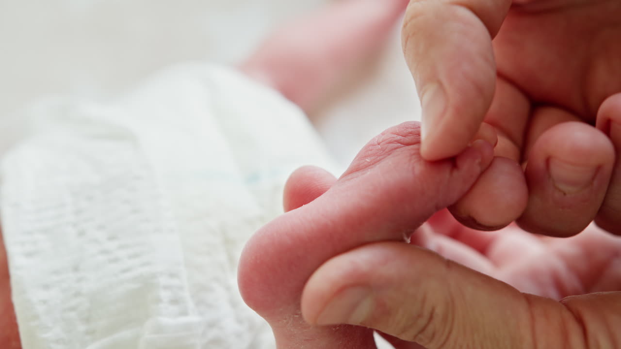 Rører ved en nyfødt babys fod