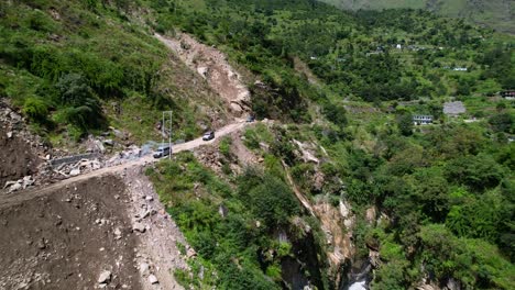 group of suv offroad cars drive on narrow mountain dirt road in kali gandaki gorge in central nepal aerial flyover