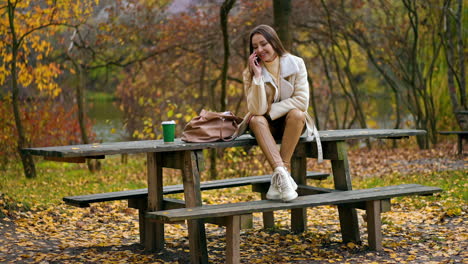 woman talking on phone in autumn park