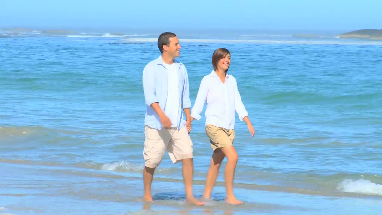 해변 을  ⁇ 고 있는 행복 한 부부