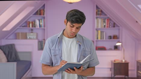 joven chico indio lindo escribiendo y pensando
