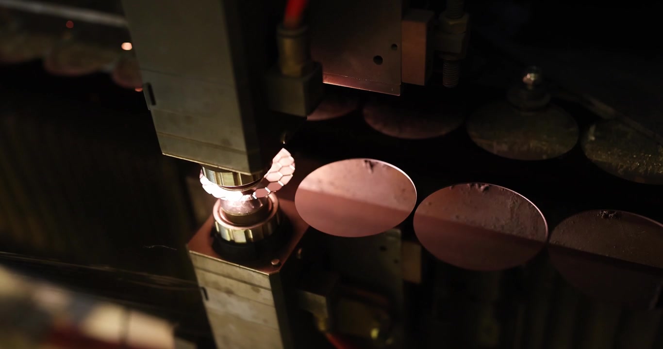 Laser machine cuts metal disks during active process