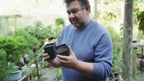 Caucasian-male-gardener-checking-plants-at-garden-center