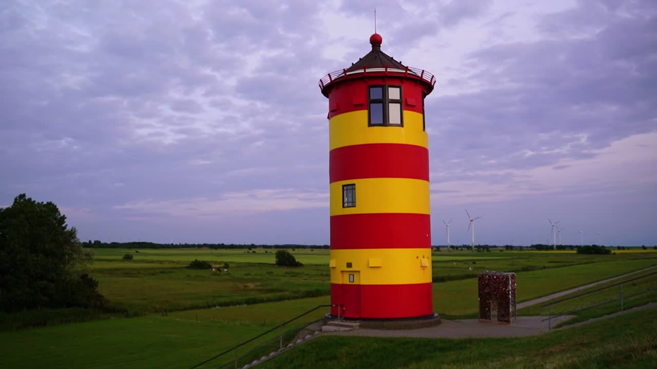 Red and yellow lighthouse in the north of Germany in front of a flat landscape