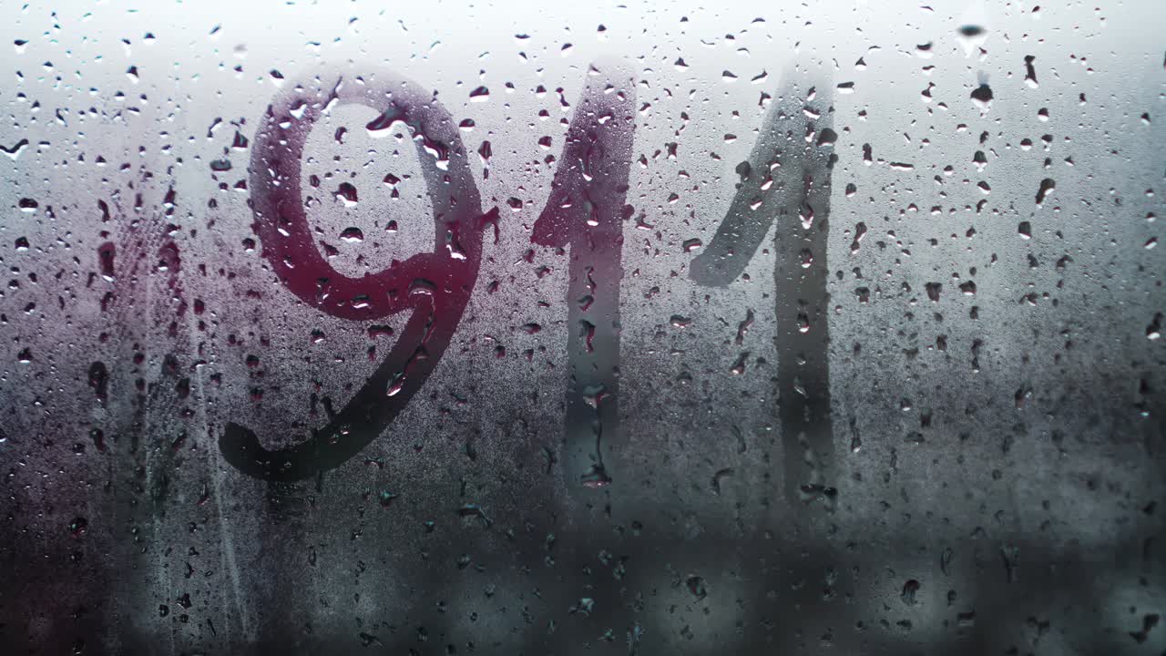 "영국어로 ""911""라는 문구가 얼어붙은 유리 위에 새겨져 있다."