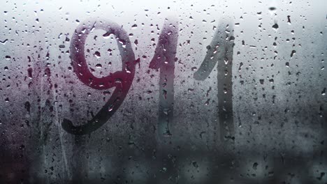 inscripción manuscrita en inglés 911 en vidrio frosted empañado.