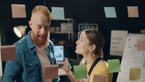 Enthusiastic-business-woman-and-professional-man-smiling-in-hipster-office.