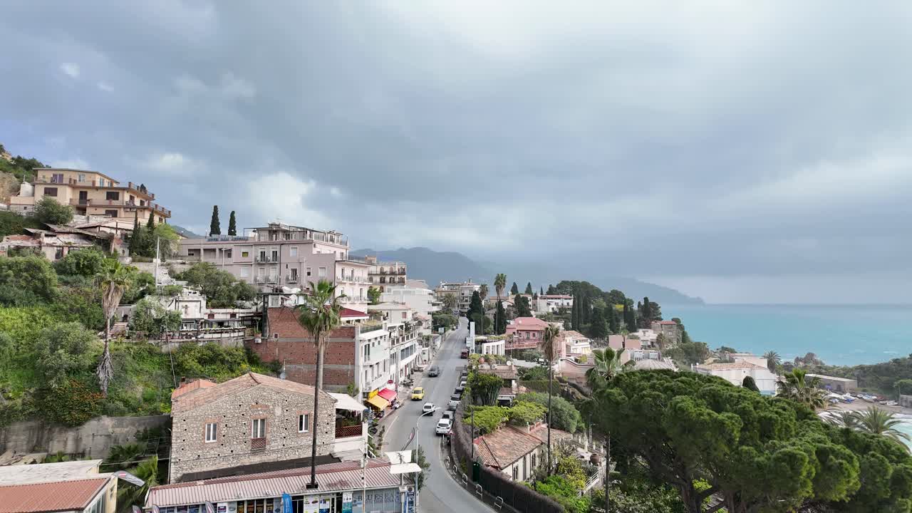 Scenic view of Taormina's coast under dramatic clouds during a timelapse
