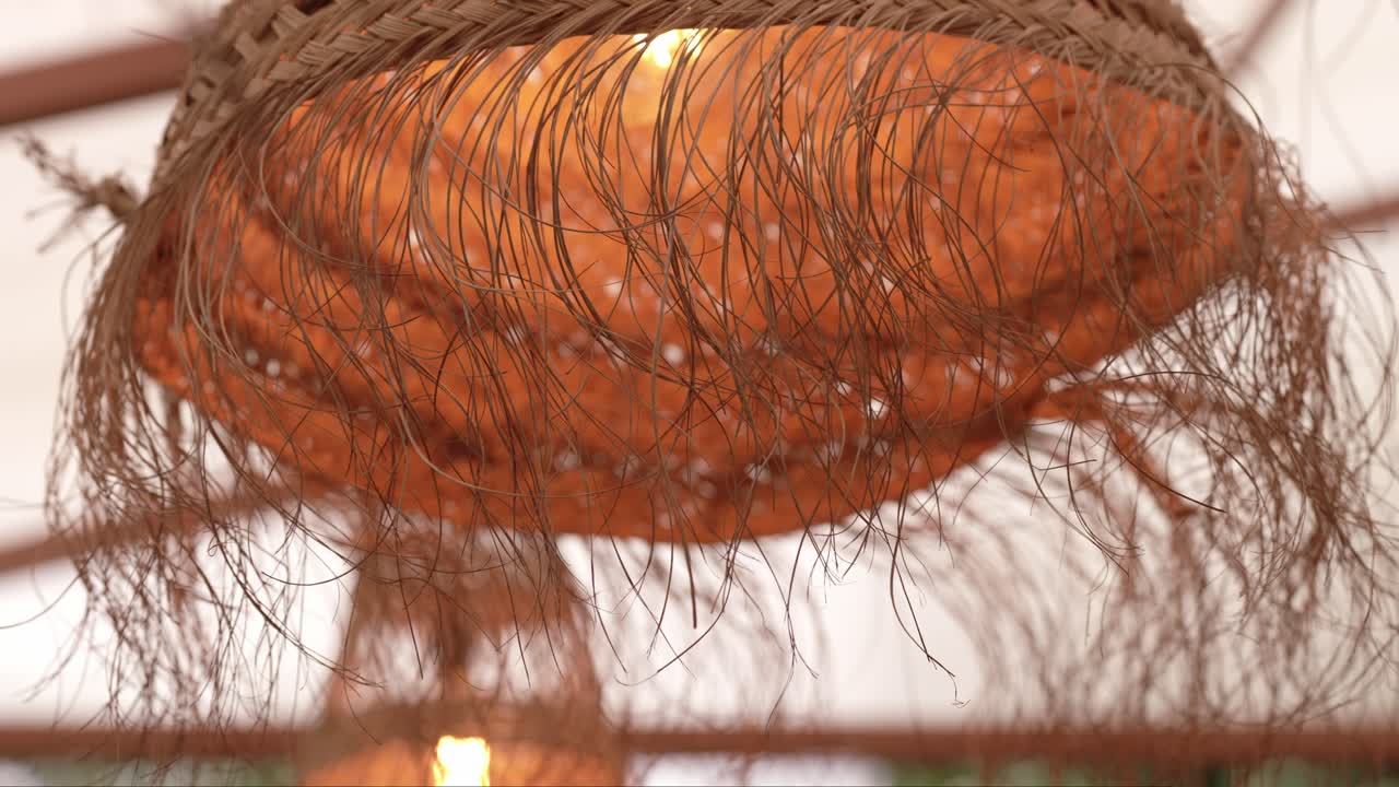 close up of textured rattan pendant light with frayed fiber details