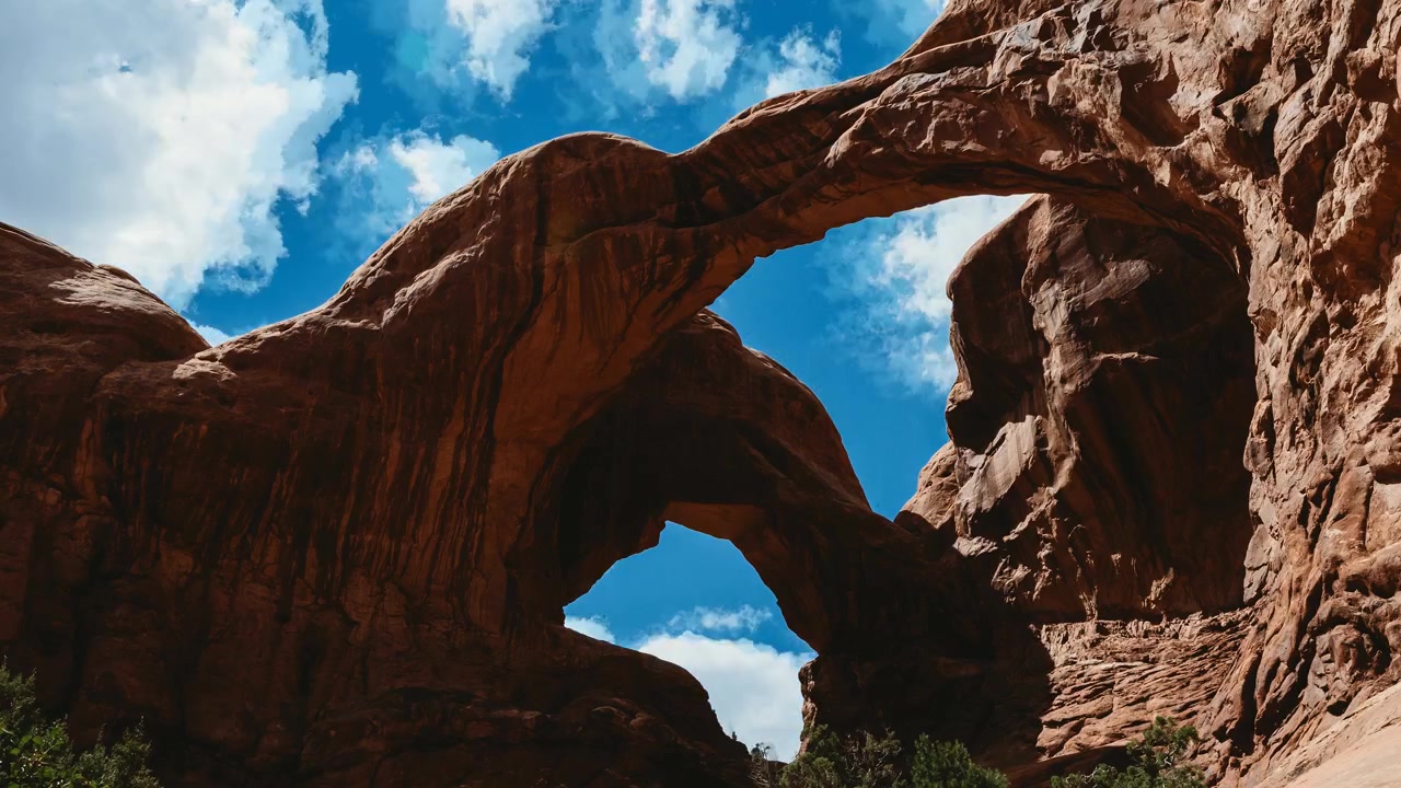 Rekaman selang waktu Double Arch Utah dengan awan siang hari