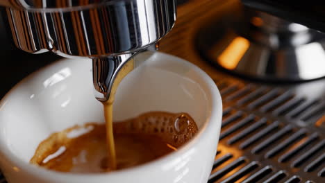 espresso brewing into a white cup