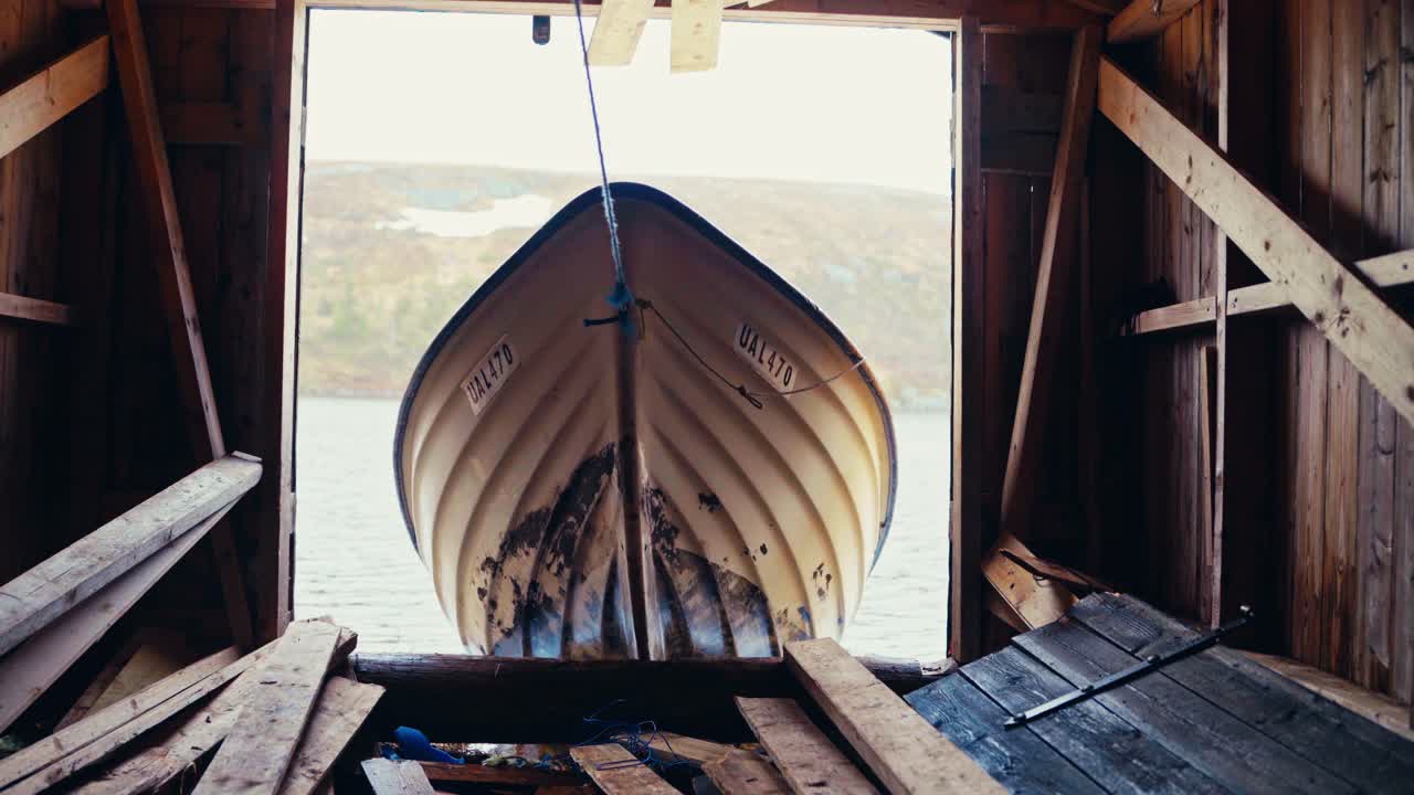 Small Boat Being Pulled Into Wooden Boathouse On Reinsjoen Lake In Afjord, Norway. static shot