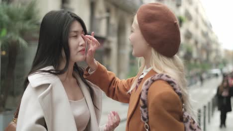 two women in stylish outfits on a city street