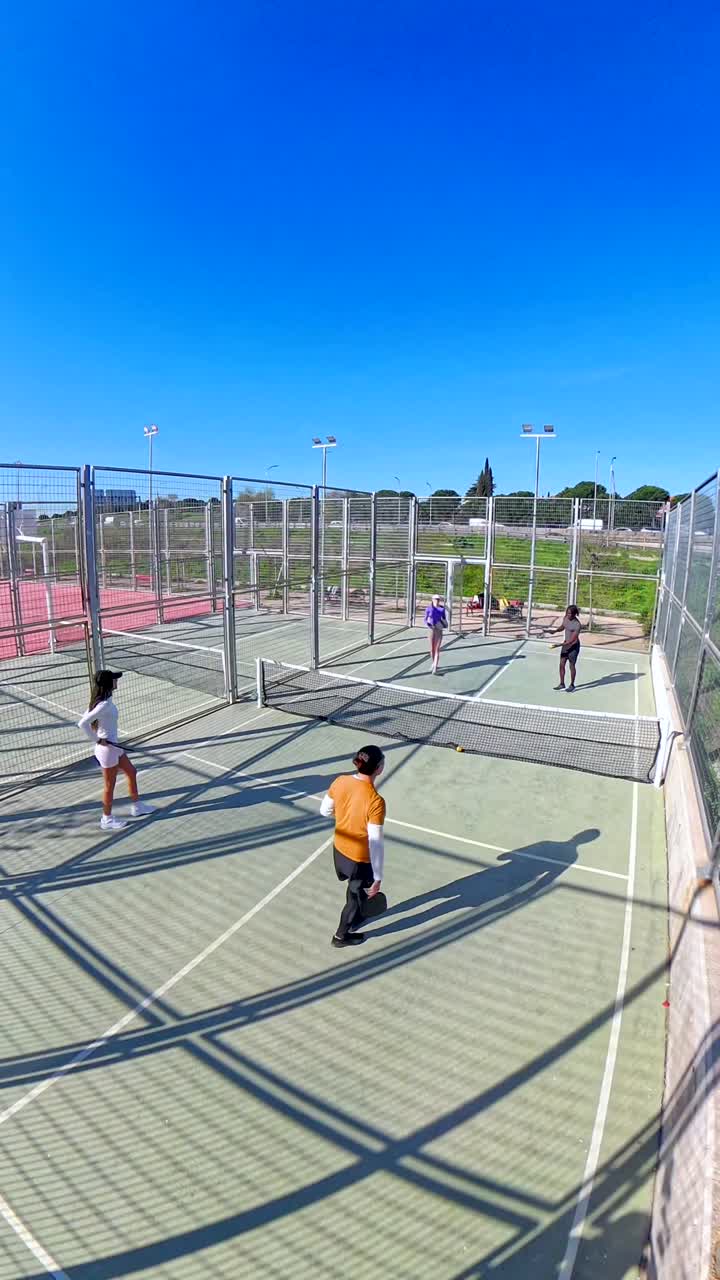 Quattro persone che giocano a padel su un campo all'aperto in una giornata di sole